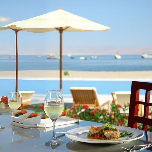 Lunch by the sea in Paracas Seafood lunch with white wine at a beachfront restaurant table overlooking Paracas Bay