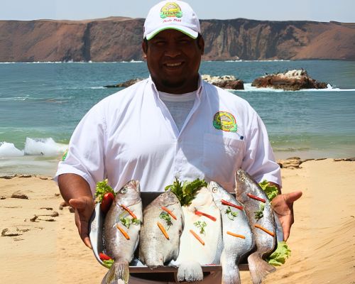 Fresh seafood in Paracas Local chef holding a platter of fresh whole fish on the beach in Paracas