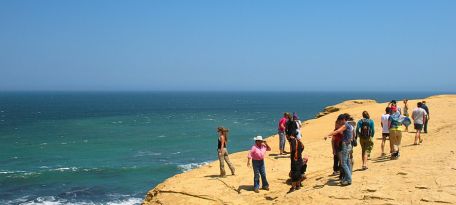 Nazca Lines Paracas Day Trip 3 Travelers enjoying the stunning cliffs and ocean views in Paracas National Reserve.