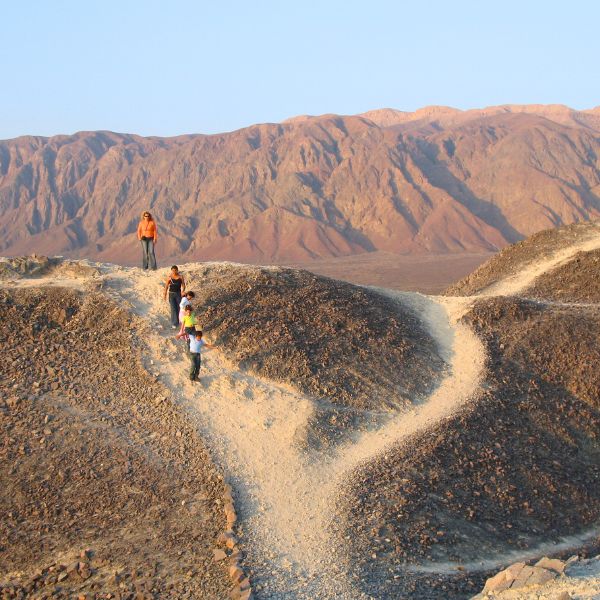 Tourists walking among desert ridges in Nazca