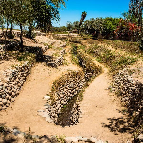 Ancient Nazca aqueduct channel with stone walls.
